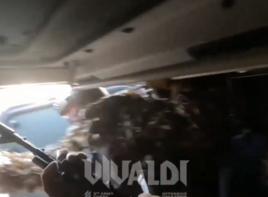 3rd Army Corps troops disembark from an armored vehicle.